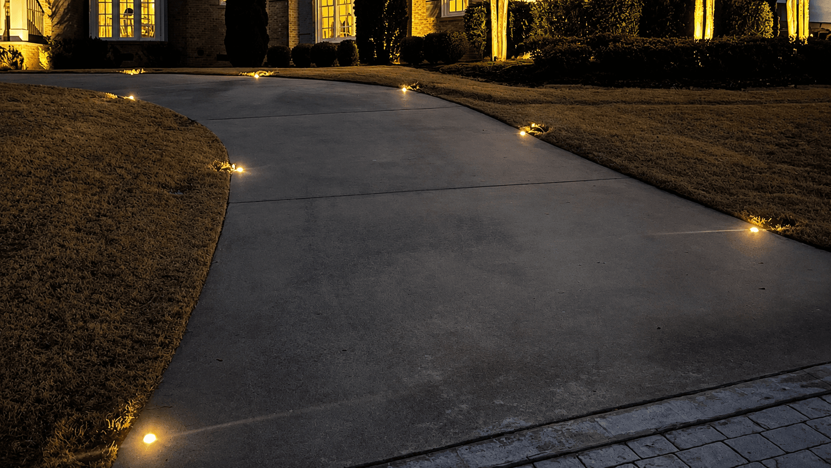 Landscape lighting along a residential driveway and planting beds
