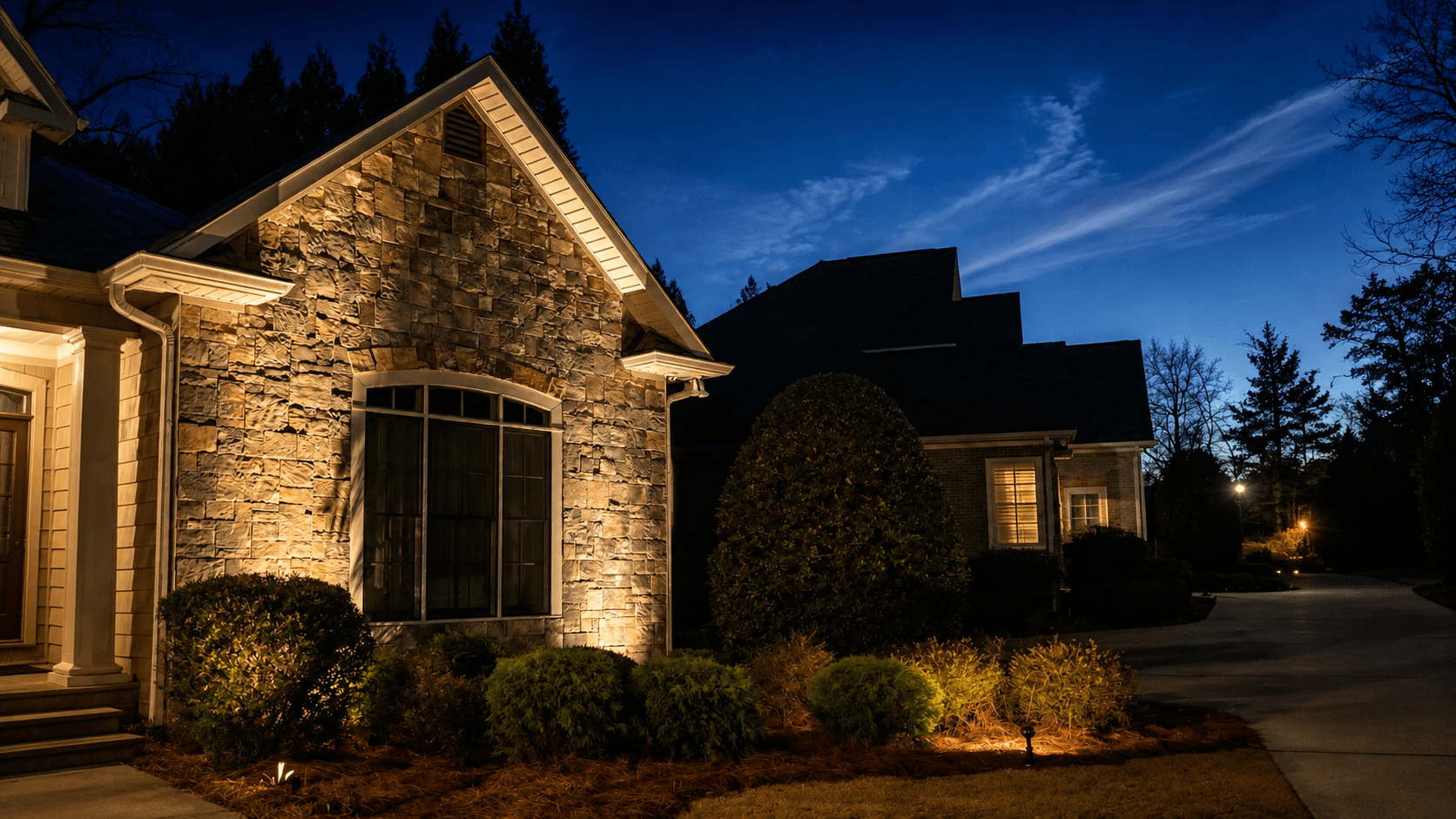 Landscape lighting highlighting a stone entry and walkway