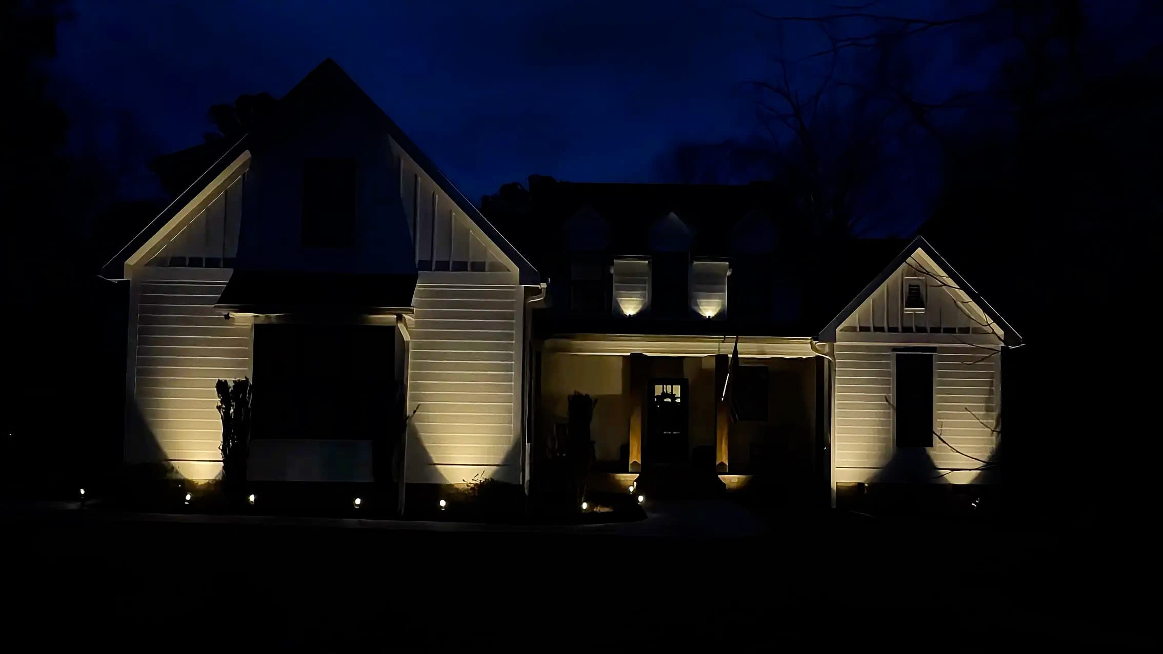 Architectural and landscape lighting across a landscaped home exterior